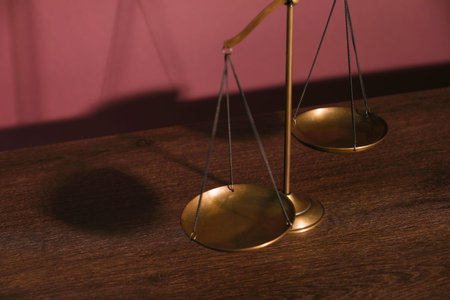 Scales of justice on table, closeup view
