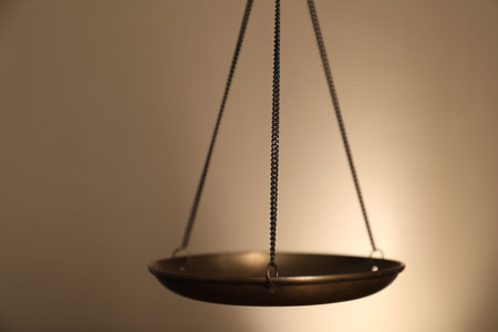 Scales of justice on beige background, closeup