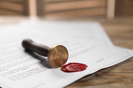 Documents with wax seal and stamp on wooden table, closeup
