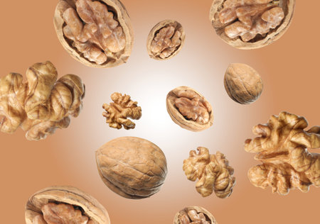 Walnuts swirling in air against pale brown background