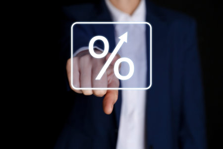 Businessman touching percent sign on virtual screen against black background, closeup