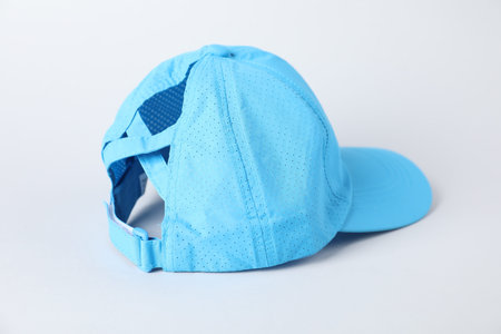 One light blue baseball cap on grey background, closeup. Mockup for design