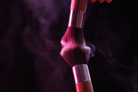 Makeup brushes with color eye shadow on black background, closeup