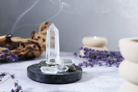 Aura. Different crystals, lavender, burning candle on white textured table, closeupの写真素材