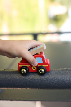 Little boy playing with toy car outdoors, closeup