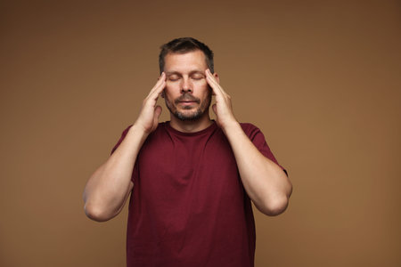 Panic attack. Man calming himself down on brown background