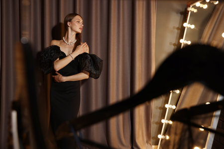 Beautiful woman getting ready near mirror indoors