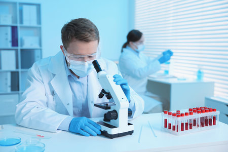 Medical analysis. Scientist working with microscope in laboratory, selective focus