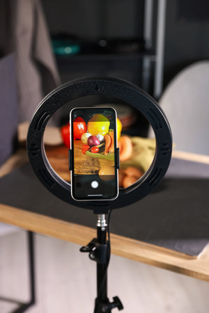 Shooting vegetables with smartphone in studio, focus on screen. Professional food photography
