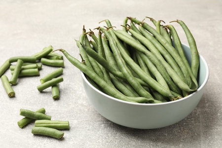 Many raw green beans on gray table, closeup