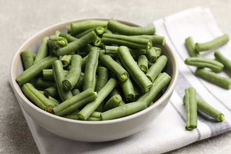 Many raw green beans on gray table, closeup