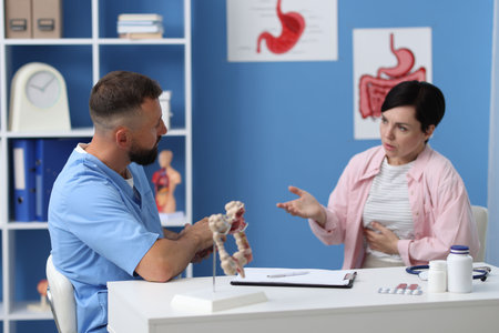 Gastroenterologist consulting patient with stomach pain in clinic