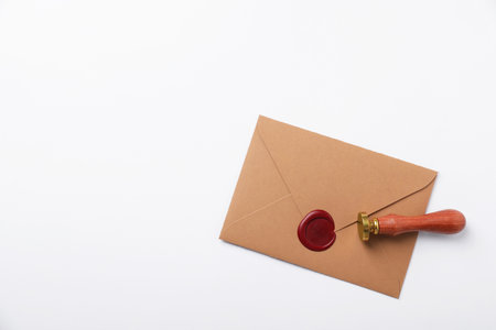 Envelope with wax seal and stamp on white background, top view. Space for textの写真素材