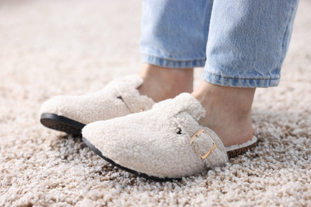 Woman in white slippers on soft carpet, closeupの写真素材