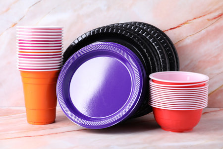 Set of disposable dishware on pink marble table