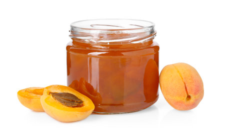 Tasty apricot jam in jar and fresh fruits isolated on whiteの写真素材