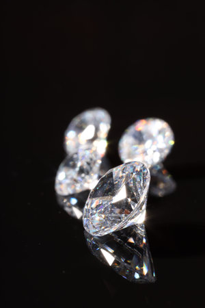 Shiny diamonds on mirror surface against black background, closeupの写真素材
