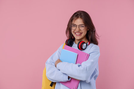 Student feeling happy about her good exam result on pink backgroundの写真素材