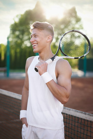 Happy man with racket at tennis courtの写真素材