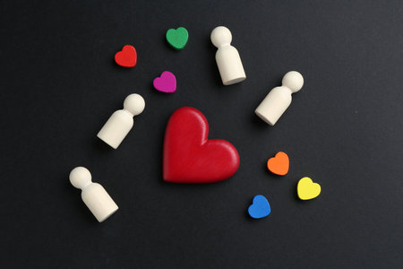 Tolerance concept. Human figures and colorful hearts on black background, flat layの写真素材