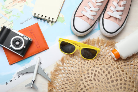 Time for summer vacation. World map, toy plane, passport, camera, notebook, shoes and beach...