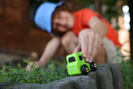 Little boy playing with toy car outdoors, selective focusの写真素材