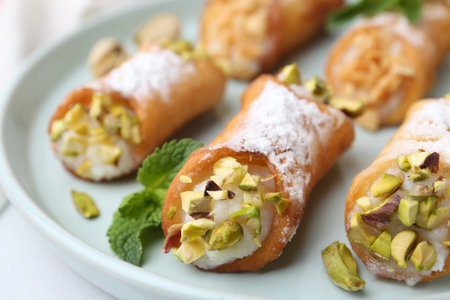 Delicious cannoli with nuts and mint on table, closeup