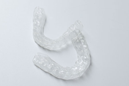 Clear aligners on light gray background, closeup