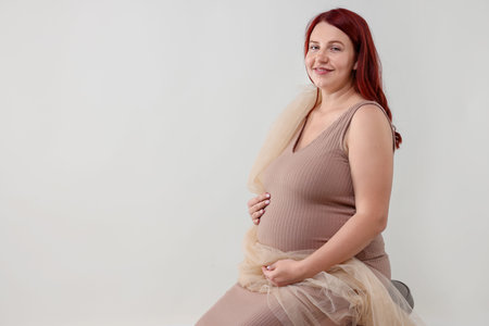 Beautiful pregnant woman on light grey background, space for text