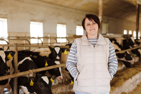 Portrait of farmer near cute cows inside cowshed in dairy farm