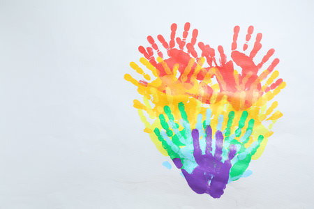 Tolerance concept. Heart of colorful handprints on white background, top view. Space for textの写真素材