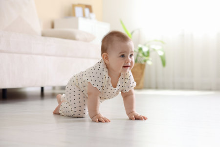 Cute little baby crawling on floor at homeの写真素材