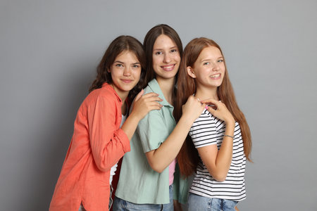 Portrait of happy friends on grey backgroundの写真素材