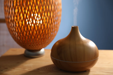Modern aroma lamp on wooden table indoors, closeup