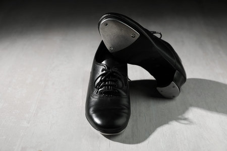 Pair of shoes for tap dance on white wooden floor