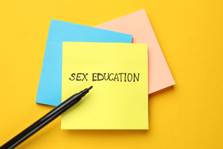 Sticky notes with words Sex Education and felt pen on yellow background, flat layのeditorial素材