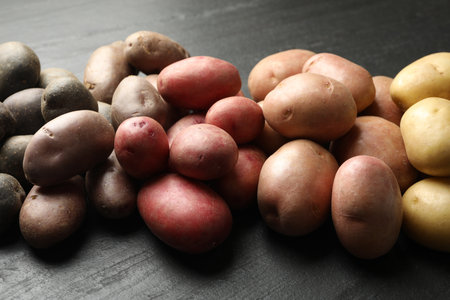 Different types of potatoes on black table, closeupの写真素材