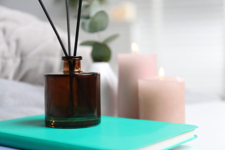 Spa composition with reed air freshener and book indoors, closeup