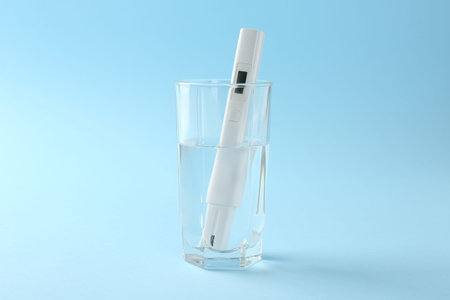 Nitrate tester in glass of water on light blue backgroundの写真素材