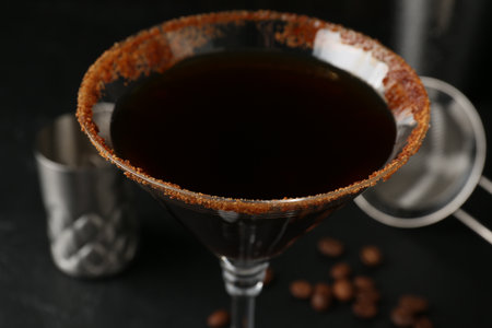 Martini cocktail with sugar in glass and coffee beans on black table, closeupの写真素材