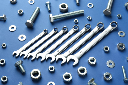Metal wrenches, nuts and bolts on blue background, flat layの写真素材