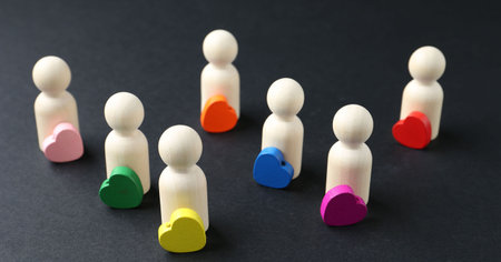 Tolerance concept. Human figures and colorful hearts on black background, closeup