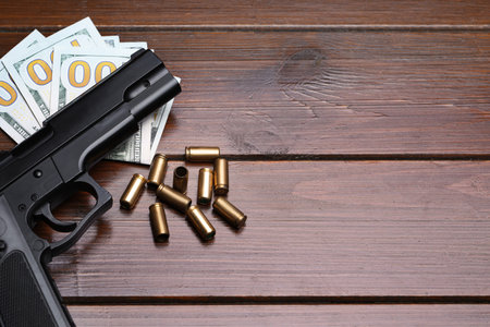 Bullets, gun and dollars on wooden table, flat lay. Space for textのeditorial素材