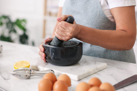 Senior woman cooking at white marble table in kitchen, closeupの写真素材