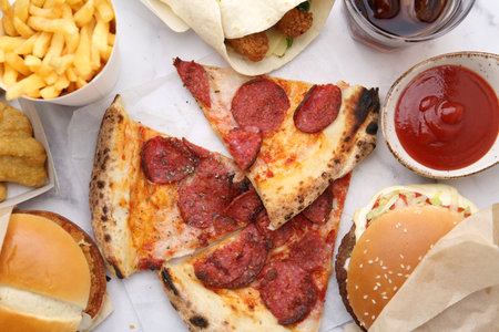 Different delicious fast food and soda drink on white marble table, flat layの写真素材