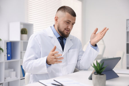 Doctor having online consultation via tablet indoorsの写真素材