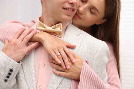 Making marriage proposal. Woman with engagement ring and her smiling fiance hugging at home, closeupの写真素材
