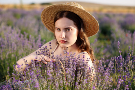 Beautiful young woman among lavender flowers in fieldの写真素材