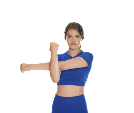Teenage girl in sportswear stretching on white backgroundの写真素材