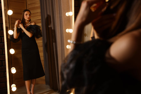 Woman brushing her hair while getting ready near mirror indoorsの写真素材